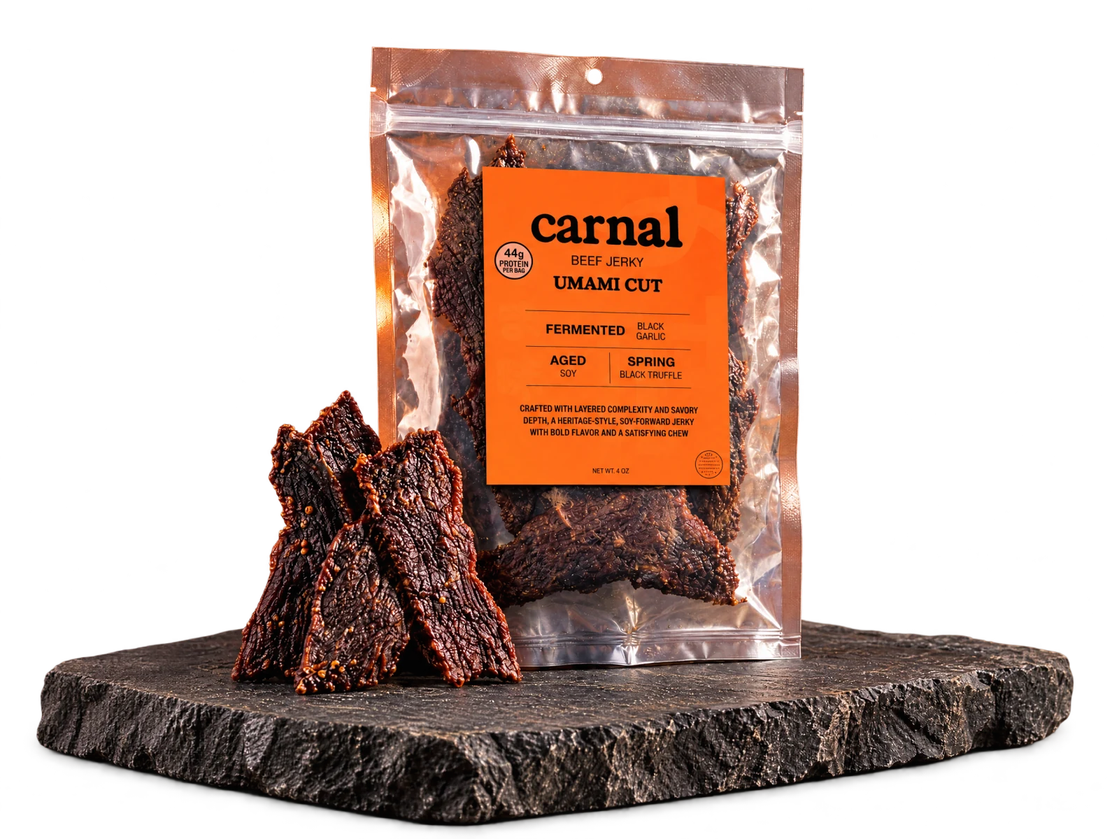 Carnal Umami Cut jerky bag with thick-cut jerky on a slate serving slab